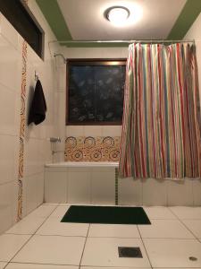 a bathroom with a shower curtain and a window at Belle Ville in Sucre