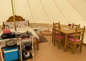 a room with a bed and a table and chairs at Glamp At The Priory in Aldeby