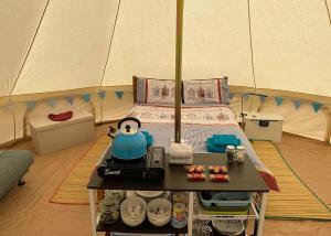 a room with a tent with a bed and a table at Glamp At The Priory in Aldeby
