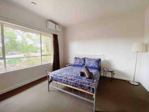 a bedroom with a bed and a large window at large Group house in Windy Corner