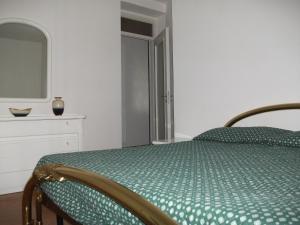 a bedroom with a bed with a green comforter at Casa Lanze in Castagnole Lanze