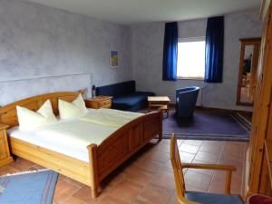 a bedroom with a bed and a chair and a couch at Hotel Leo's Ruh in Waldböckelheim