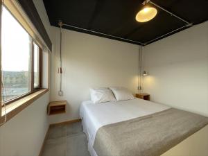 sypialnia z łóżkiem i dużym oknem w obiekcie Hotel Big Sur w mieście Puerto Natales