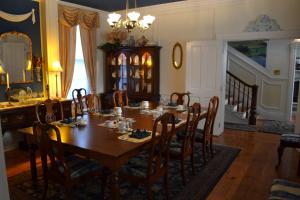 EJ Bowman House Bed & Breakfast في لانكستر: غرفة طعام مع طاولة وكراسي خشبية