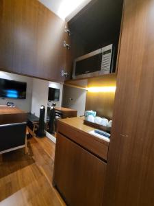 a room with a kitchen with wooden cabinets and a room with a table at Baiton Seoul Dongdaemun in Seoul