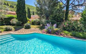 a swimming pool in a yard with flowers and trees at Nice Home In Berlou With Wifi, Private Swimming Pool And 3 Bedrooms in Berlou