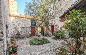 a courtyard of a stone building with flowers and plants at Nice Home In Berlou With Wifi, Private Swimming Pool And 3 Bedrooms in Berlou