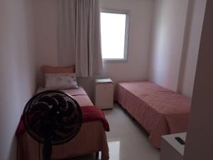 a small bedroom with two beds and a window at Lindo AP na Praia da Costa melhor bairro da cidade in Vila Velha