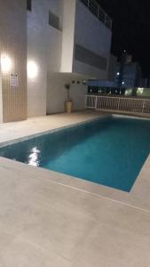 a large swimming pool in a building at night at Lindo AP na Praia da Costa melhor bairro da cidade in Vila Velha