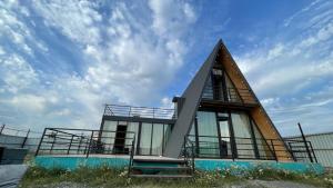 a small house with a triangular roof on top at Alagi Cottage at Bazaleti lake in Grigolaantkari