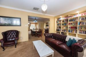 sala de estar con sofá, sillas y mesa en Ayr House - Echuca Holiday Homes en Echuca