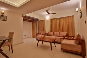 a living room with a couch and a table at Lagoona Beach Resort, Kovalam in Kovalam