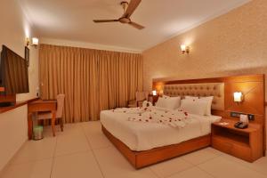 a hotel room with a bed with flowers on it at Lagoona Beach Resort in Kovalam