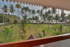 a balcony with a view of a park with palm trees at Lagoona Beach Resort, Kovalam in Kovalam