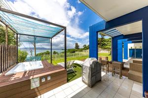 a bathroom with a tub and a patio at Hermit Hills Okinawa  -SEVEN Hotels and Resorts- in Onna