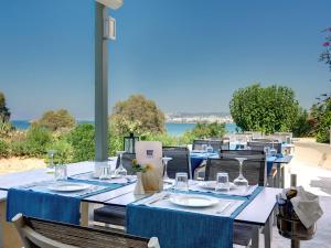 a group of tables with plates and glasses on them at Forum Suites in Kato Daratso