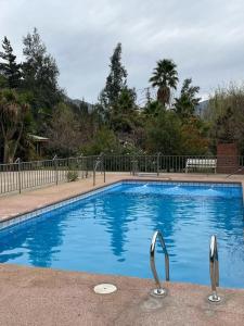 a large blue swimming pool with two metal handles at Cabañas Los Olmos in San José de Maipo