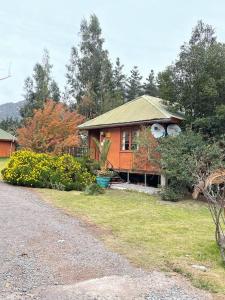 a house with a yard and a driveway at Cabañas Los Olmos in San José de Maipo