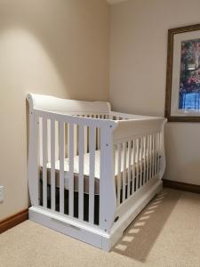 a white crib in a corner of a room at Honeymoon Suite in West Kelowna