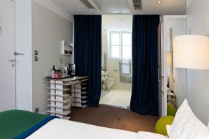 a bedroom with a bed and a mirror and a bathroom at Hotel Le Placide Saint-Germain Des Prés in Paris