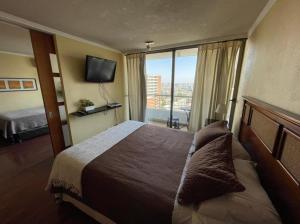 Habitación de hotel con cama y ventana grande en Espacio M Providencia, en Santiago