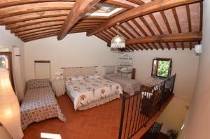 una camera con 2 letti e un soffitto in legno di Al Vecchio Pozzo a Buti