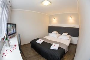 ein kleines Schlafzimmer mit einem Bett mit weißen Kissen in der Unterkunft Apartament Lazur in Piła