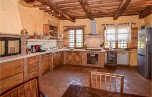 a large kitchen with wooden cabinets and a refrigerator at 3 Bedroom Awesome Home In Civitella Dagliano in Civitella dʼAgliano