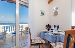 a dining room with a table and a view of the ocean at Nice Home In Medveja With House Sea View in Medveja