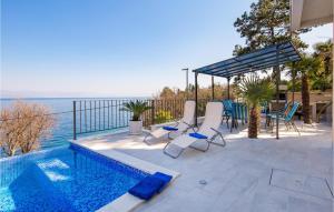 a patio with chairs and a swimming pool and the ocean at Nice Home In Medveja With House Sea View in Medveja
