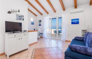 un salon avec un canapé bleu et une télévision dans l'établissement Nice Home In Medveja With House Sea View, à Medveja