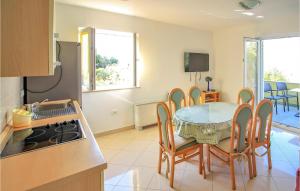 cocina y comedor con mesa y sillas en Beach Front Apartment In Mandre With Kitchen, en Mandre
