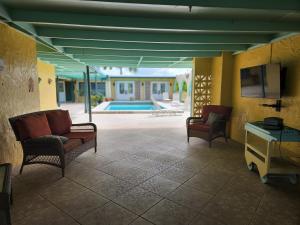 a living room with chairs and a tv and a pool at The View in Christiansted