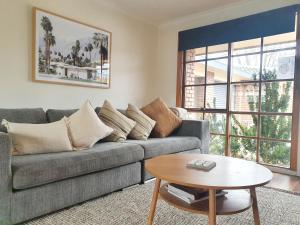 ein Wohnzimmer mit einem Sofa und einem Tisch in der Unterkunft Olive Street Apartment in Albury