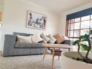 uma sala de estar com um sofá e uma mesa em Olive Street Apartment em Albury