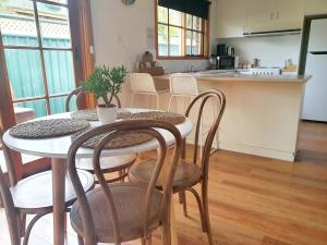a kitchen with a table and chairs and a kitchen with a counter at Olive Street Apartment in Albury