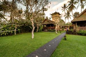 a walkway in front of a house with a building at Tanah Merah Art Resort in Ubud
