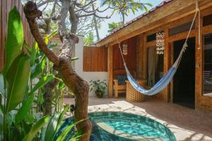 a hammock on the patio of a house at Jawa House Private Villas in Gili Trawangan