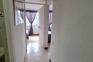 un corridoio con una camera con tende viola di Hermoso Apartamento en excelente ubicación. a Medellín