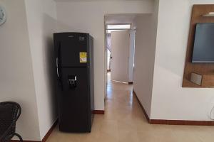 um frigorífico preto num quarto com um corredor em Hermoso Apartamento en excelente ubicación. em Medellín