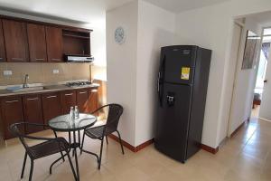 uma cozinha com uma pequena mesa e um frigorífico em Hermoso Apartamento en excelente ubicación. em Medellín