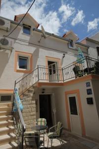 ein Haus mit einem Balkon mit Stühlen und einer Treppe in der Unterkunft Apartments by the sea Baska Voda, Makarska - 6869 in Baška Voda
