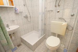 ein Bad mit einem WC, einer Dusche und einem Waschbecken in der Unterkunft Apartments by the sea Baska Voda, Makarska - 6869 in Baška Voda