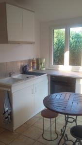a kitchen with a sink and a table in it at Pis-en-lits in Vire-sur-Lot