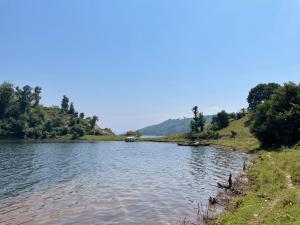 a body of water with trees on the side at Twin Lakes Recreational Island in Ryandinzi