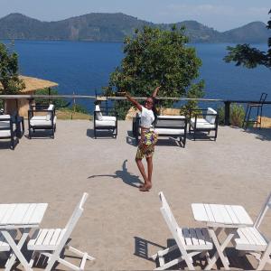 a man standing in front of a group of chairs at Twin Lakes Recreational Island in Ryandinzi