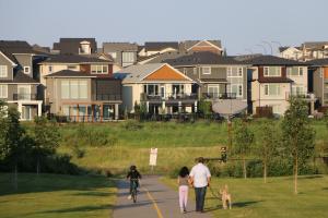 a group of people and a dog walking down a road with houses at Guest Suite in Calgary in Calgary