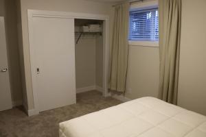 a bedroom with a white bed and a window at Guest Suite in Calgary in Calgary