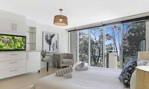 a bedroom with a bed and a flat screen tv at Little Cove Court - Apt 4 in Noosa Heads +4 photos
