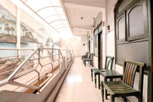 un couloir d'un train avec des chaises et des peintures sur le mur dans l'établissement Hotel Gajah Mada, à Sukodono